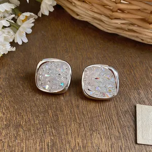 Detail view of silver-toned rhombus earrings with iridescent crushed zircon inlay.
