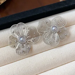 Elegant silver flower stud earrings with pearl centers and cubic zirconia details