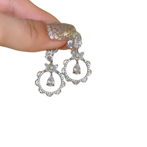 Eleganti orecchini in argento con zirconi a goccia e cornice circolare a balze