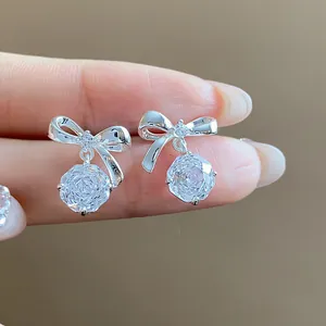 Eleganti orecchini a fiocco d'argento con pendenti in zircone cubico tondo in primo piano