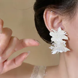 Detailed macro view of elegant white leather floral stud earrings in vintage French style