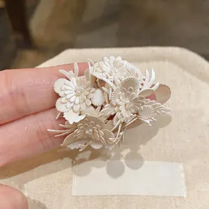 Macro detail shot of elegant French vintage leather flower stud earrings with pearls