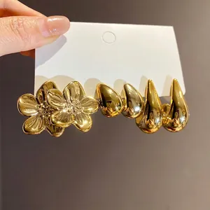 Vintage gold-tone earring set featuring flower and water drop studs on a display card
