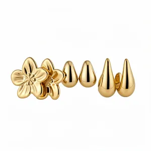 Vintage gold earring set featuring polished flowers and teardrops on white background