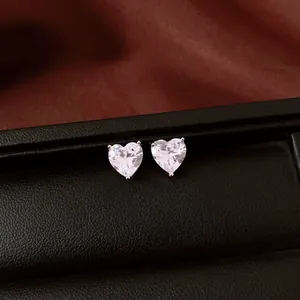 Boucles d'oreilles cœur en zircon clair sur un coffret de présentation noir de luxe