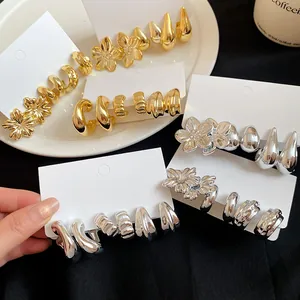 Detail of vintage floral and teardrop earring sets in gold and silver metallic finishes.