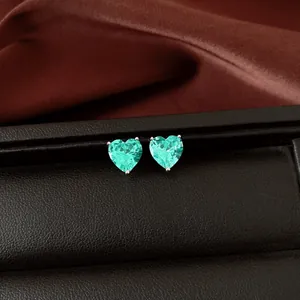 Vue macro de boucles d'oreilles en zircon cyan en forme de cœur sur une boîte à bijoux