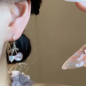 Detailed close-up view of a sweet cherry earring with heart crystal and pink resin bead