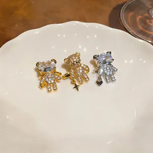 Dettaglio di orecchini a clip a forma di orso placcati oro 18k con zirconi.