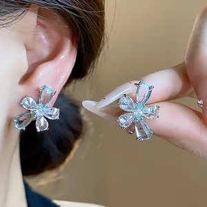 Close-up detail of sparkling zircon teardrop flower stud earrings on silver needle