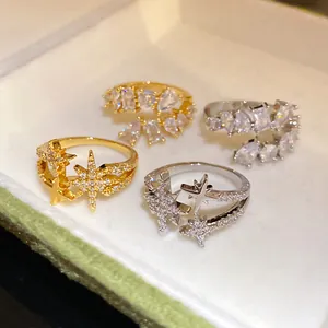 Detail shot of shimmering zircon star and geometric open rings in gold and silver finishes