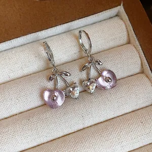 Close-up of sweet cherry earrings with pink resin and rhinestone hearts
