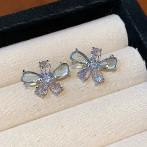 Close-up of dainty silver flower earrings with sparkling water drop zircon petals.