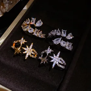 Close-up of star and geometric zirconia open rings in gold and silver finish