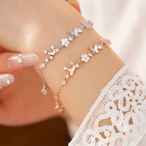 Elegant gold and silver bracelets with zircon, shell, crown, and butterfly motifs.