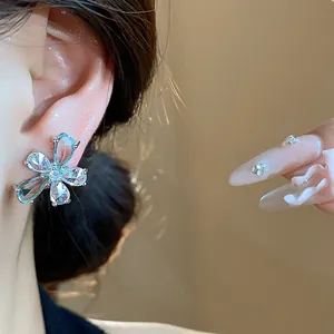Elegant zircon flower stud earring with clear water-drop shaped petals on model's ear