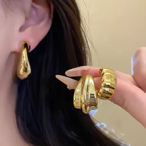Close-up detail of vintage gold water drop earrings set featuring a high-shine metallic finish