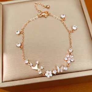 Elegant rose gold bracelet with crown, butterfly, and flower charms inlaid with zircons.