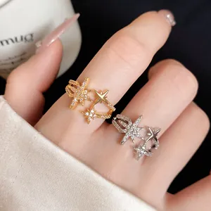 Close-up detail of exquisite gold and silver zircon star open rings on a hand
