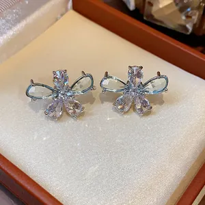 Close-up of elegant flower stud earrings featuring teardrop zircons in a jewelry box
