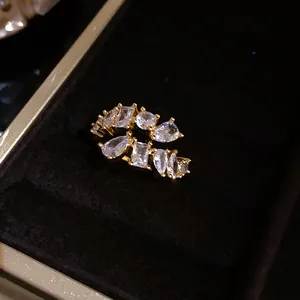 Close-up of gold open ring with various shapes of clear cubic zirconia.
