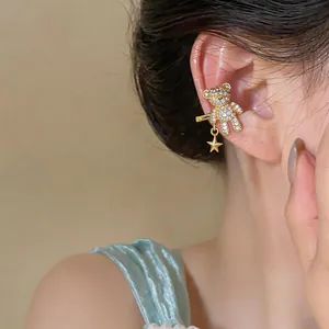 Dettaglio di un ear cuff a forma di orsetto placcato oro 18k con zirconi e stella