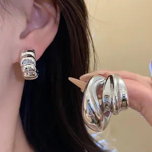 Macro view of vintage silver waterdrop stud earrings set with high-gloss metallic finish.