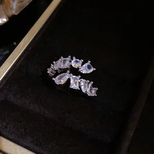 Detailed macro view of an exquisite geometric zircon cluster ring on dark black velvet