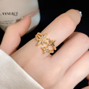 Detailed macro view of elegant gold-plated star-shaped ring with zircon stones on finger