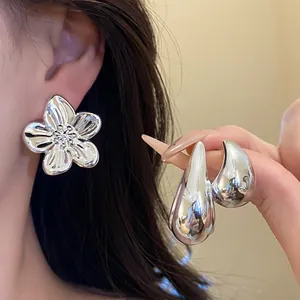 Close-up of vintage silver-tone chunky flower stud and teardrop earrings set jewelry