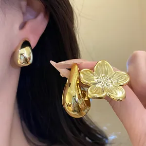 Close-up of vintage gold flower and waterdrop stud earring set with metallic luster