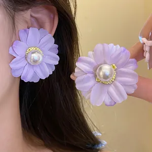 Elegant purple fabric flower earrings with a faux pearl center and silver needle post