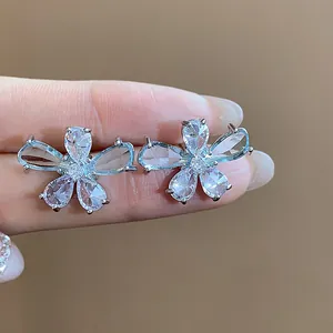 Close-up detail of exquisite silver flower stud earrings with teardrop zircon petals.