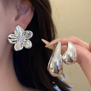 Detailed close-up shot of retro silver flower and waterdrop earring set with high-polish finish