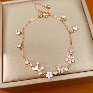 Detailed view of rose gold bracelet featuring crown, shell butterfly, and zircon flower charms