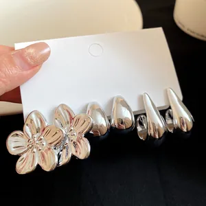 Detailed view of vintage silver floral and teardrop earring set on display card