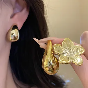 Close-up of vintage gold flower and teardrop earring set with shiny metallic finish