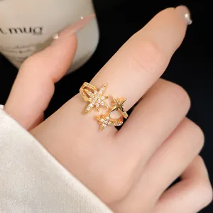 Close-up of elegant gold star open ring with sparkling zirconia crystals on finger.
