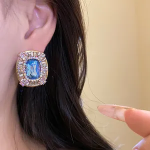 Primo piano di orecchini vintage ovali con gemma blu e strass