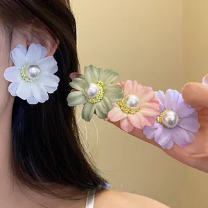 Detailed view of handmade fabric daisy earrings with pearl center in multiple pastel shades