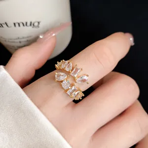 Close-up of golden geometric open ring with sparkling cubic zirconia on finger