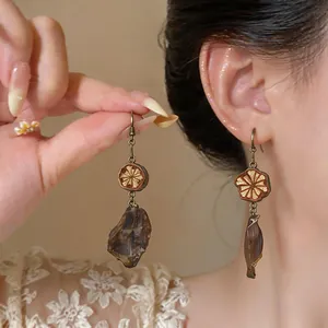 Detailed view of vintage ethnic drop earrings with carved wood and dark stone accents.