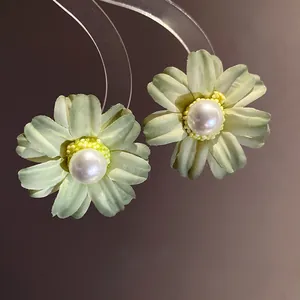 Close-up of elegant fabric flower stud earrings with center pearl for a vintage style