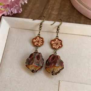 Detailed view of vintage ethnic drop earrings with wood flower and resin bead