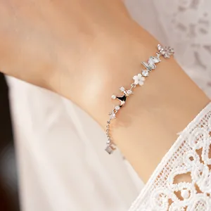 Detail view of silver bracelet with zircon crown and mother-of-pearl butterfly