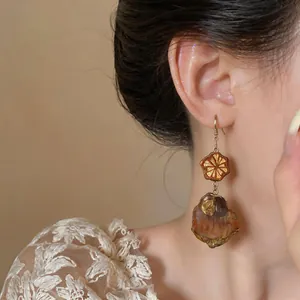Detailed view of vintage ethnic drop earrings with textured wood-like charms and hooks
