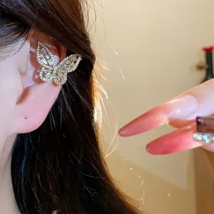 Elegant golden zircon butterfly ear cuff for non-pierced ears worn on an ear model.