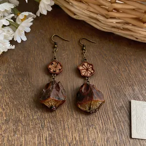 Detailed view of vintage ethnic drop earrings with carved wood and dark natural nut pendants