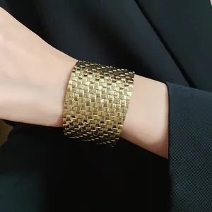 Close-up of a vintage gold mesh cuff bracelet featuring a luxury woven textured finish