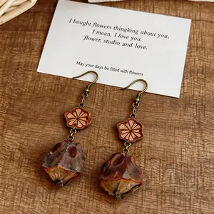 Close-up detail of retro ethnic wood drop earrings with bronze hooks